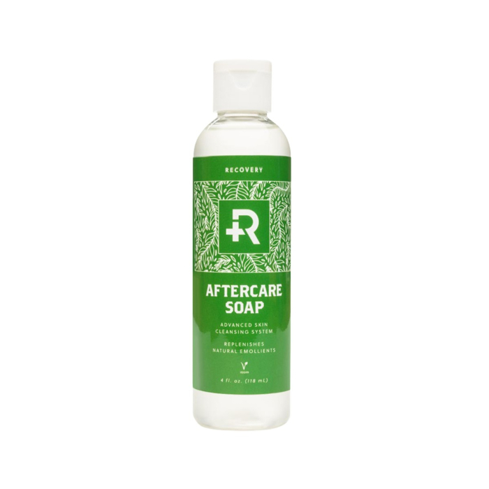 Un flacon en plastique transparent avec un bouchon à charnière contient du savon de récupération - 118 ml (4 fl. oz). L'étiquette verte et blanche présente une croix médicale et un motif de feuilles.